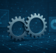 Close-up of two metallic gears with a digital background featuring graphs and data points
