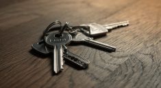 A close-up image of a set of keys on a wooden surface.