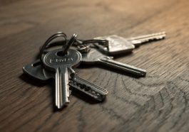 A close-up image of a set of keys on a wooden surface.
