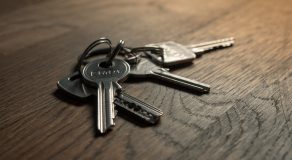 A close-up image of a set of keys on a wooden surface.