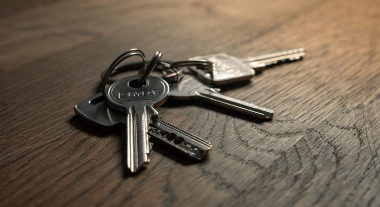 A close-up image of a set of keys on a wooden surface.