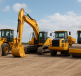 Various construction equipment including excavators and rollers on a dirt surface.